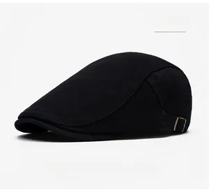 Detail of black twill flat cap with side metal adjustable buckle on white background