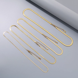 Detailed view of four different widths of gold herringbone necklaces with extender chains
