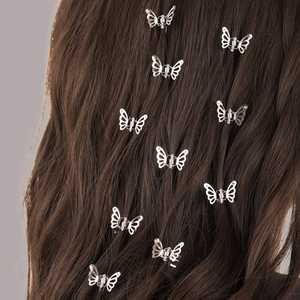 Set of nine silver metal butterfly mini hair clips worn on a model's brown hair