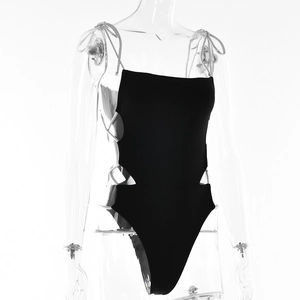 Detail view of black one-piece swimsuit featuring side lace-up cutouts and slim straps