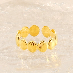 Macro shot of gold adjustable shell ring showing detailed metal texture and design