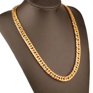 Macro view of gold stainless steel Cuban link chain necklace on a display bust