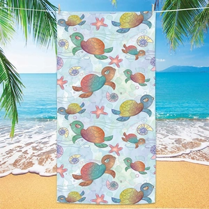 Microfiber beach towel with cartoon sea turtle and starfish hanging by the blue ocean