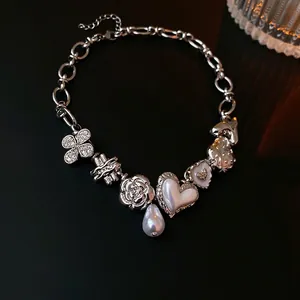 Silver chain necklace featuring charms of clover, heart, strawberry, and rose with pearl