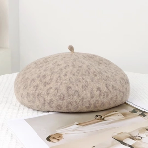 Close-up of leopard print wool beret with soft texture on a woven background