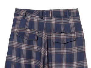 Close-up of blue plaid cargo pants featuring back pockets with flaps and fine fabric texture