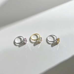 Detailed view of three minimalist rings with pink, clear, and yellow radiant cut stones