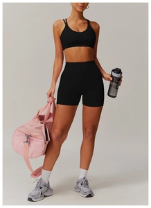 Detail of black seamless yoga set showing cross back sports bra and high waist gym shorts