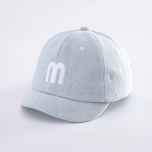 Detailed shot of baby denim baseball cap with white embroidered letter M and soft brim