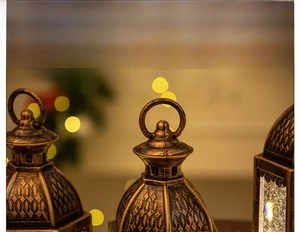 Detail of vintage bronze Christmas lantern with ornate embossed patterns and ring handle
