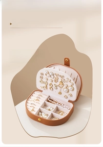 Detail view of brown semi-circular jewelry box with ring slots and earring holders
