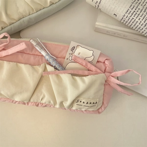 Detail of quilted fabric pencil case with blue bow ties and SOZAKKA brand patch