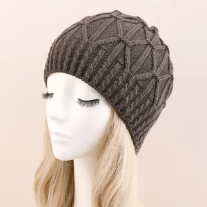 Detail der dunkelbraunen Strickmütze mit dickem Rautenmuster auf einem Modelkopf