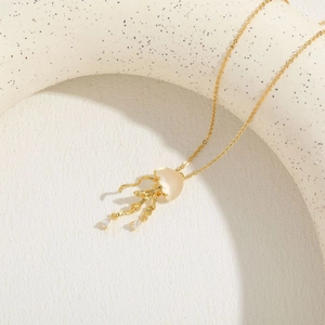 Detail showing gold jellyfish pendant with opal-like stone and zircon droplets