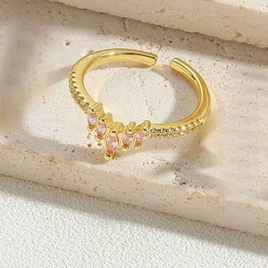 Macro detail of crown-shaped gold adjustable ring with pink marquise and white crystals