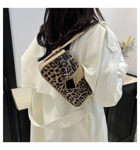 Detail of leopard print crossbody bag with beige strap and metal hardware details