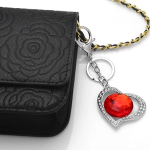 Sparkling red crystal heart keychain with rhinestone frame on a black leather bag