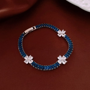 Macro detail of deep blue rectangle gems and white zircon flowers on silver bracelet