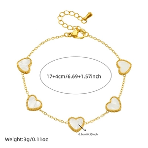 Gold chain bracelet with white shell heart charms and beaded borders on white background