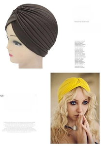 Detail of twisted knot pleated turban hat in dark brown and yellow knit fabric