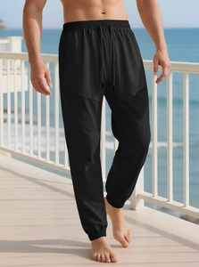 Close-up of black drawstring joggers with a subtle checkered fabric texture on a model