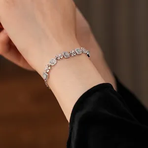 Bracelet luxueux en argent avec fleurs en zircon et pierres œil-de-chat sur le poignet