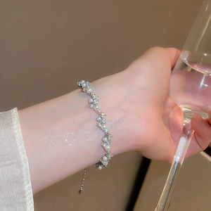 Detail of silver wavy pearl bracelet with zircons on wrist in an elegant setting