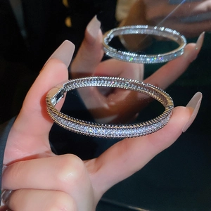 Macro shot of silver bangle featuring cubic zirconia pavé and beaded edge details
