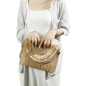 Handwoven raffia straw envelope clutch with tassel detail for women on white background