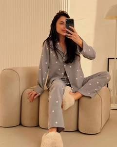 Mirror selfie of woman wearing grey pajama set with white heart print on modern sofa