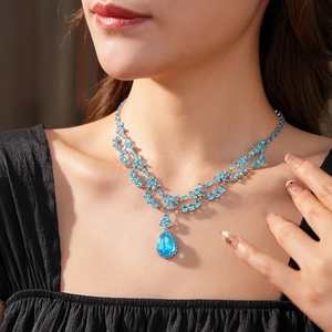 Détail d'un collier en cristal vintage avec un pendentif en pierre bleue en forme de poire