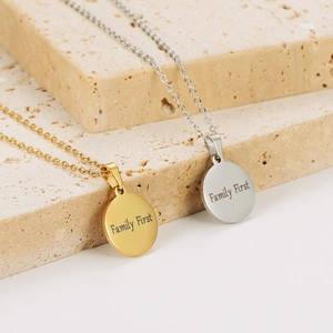 Gold and silver round coin necklaces engraved with Family First text on stone base