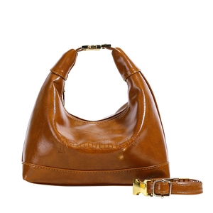 Brown half-moon leather handbag with gold metal buckles and a detachable shoulder strap