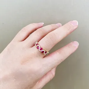 Luxurious gold wavy ring with five oval red rubies and sparkling zircon accents