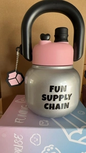 Detail showing kettlebell shaped stainless steel bottle with pink lid and black handle