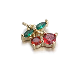 Detail shot of 14k gold cherry pendant with red and green cubic zirconia for DIY jewelry