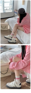 Detail of college style mid-calf socks with pink stripes and embroidered smiley face
