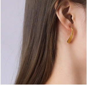 Polished gold water drop earrings shown on model for a minimalist aesthetic