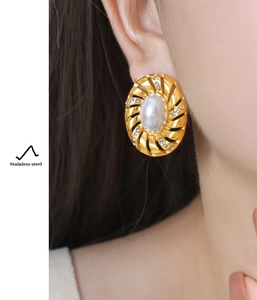 Détails de boucles d'oreilles vintage dorées avec perle et pavé de strass portées