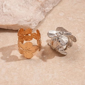 Macro shot of 3D textured gold and silver floral rings with intricate petal details
