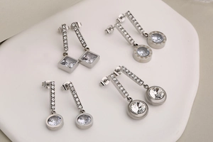 Detailed set of silver stainless steel earrings with square and round zircon settings