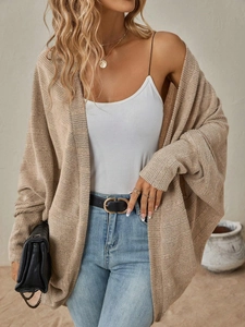 Dettaglio del cardigan in maglia beige con maniche a pipistrello e trama del tessuto fine