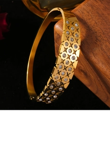 Macro view of gold-plated hollow geometric bangle with sparkling pavé diamond inlay