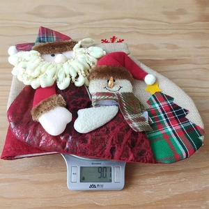 Close-up of a large 3D Christmas stocking weighing 90.1g on a scale for festive decor