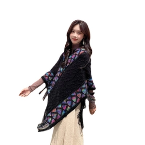 Ethnic knit poncho with geometric patterns and fringe hem on white background