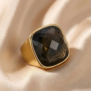 Macro shot of gold-plated ring with large square smoky quartz gemstone on silk