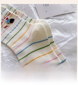 Detail of reinforced heel and dachshund embroidery on white cotton mid-calf socks