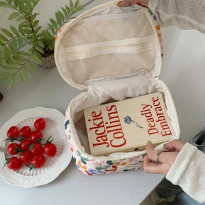 Detailed interior of a floral makeup bag featuring double zippers and mesh storage pockets