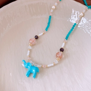 Dettaglio della collana di perline con ciondolo a elefante azzurro e perline colorate