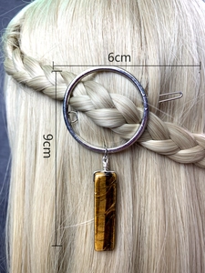 Detailed view of hair clip with 6cm silver ring and 9cm tiger eye stone pendant on hair